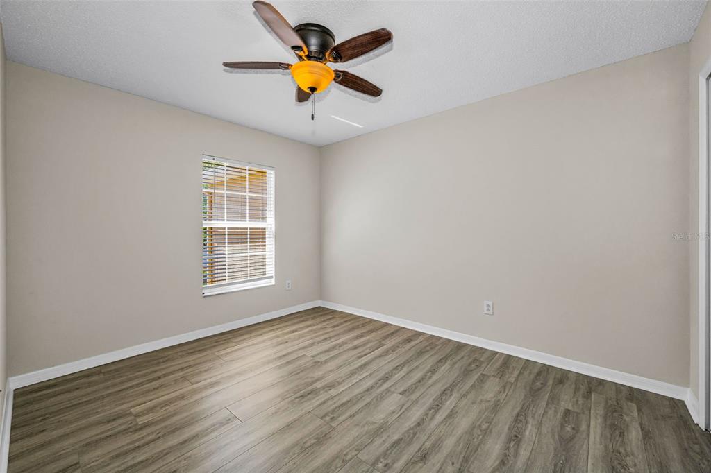 8015 Savannah Sunset Lane Tampa, FL 33615 - Photo 22 of 35 an empty room with a window and wooden floor