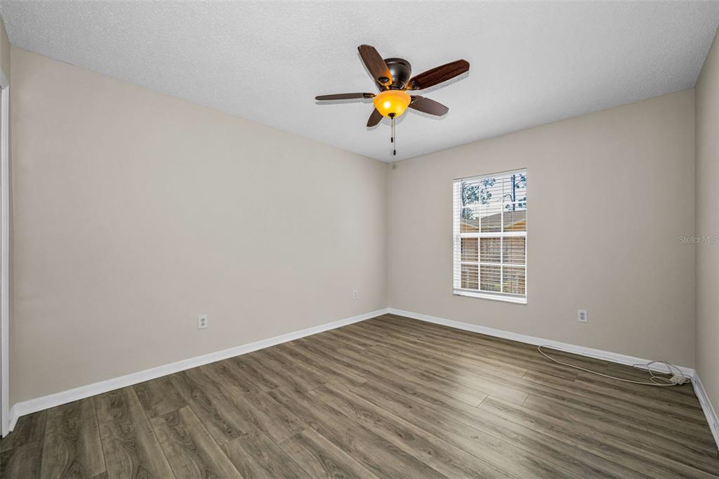 8015 Savannah Sunset Lane Tampa, FL 33615 - Photo 25 of 35 an empty room with wooden floor and windows