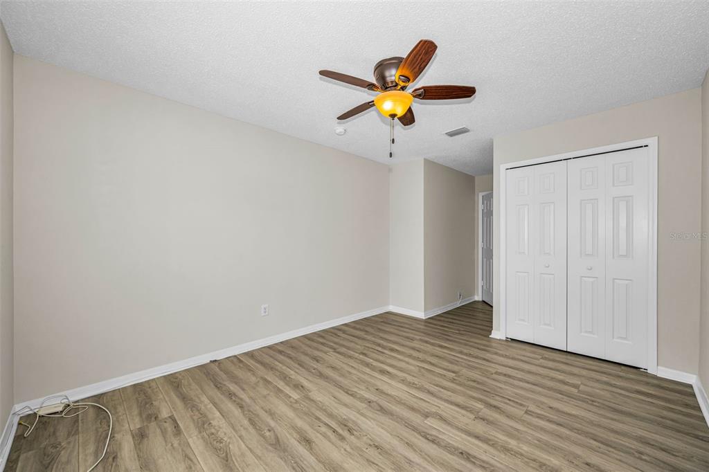 8015 Savannah Sunset Lane Tampa, FL 33615 - Photo 26 of 35 a view of a livingroom with wooden floor and a ceiling fan