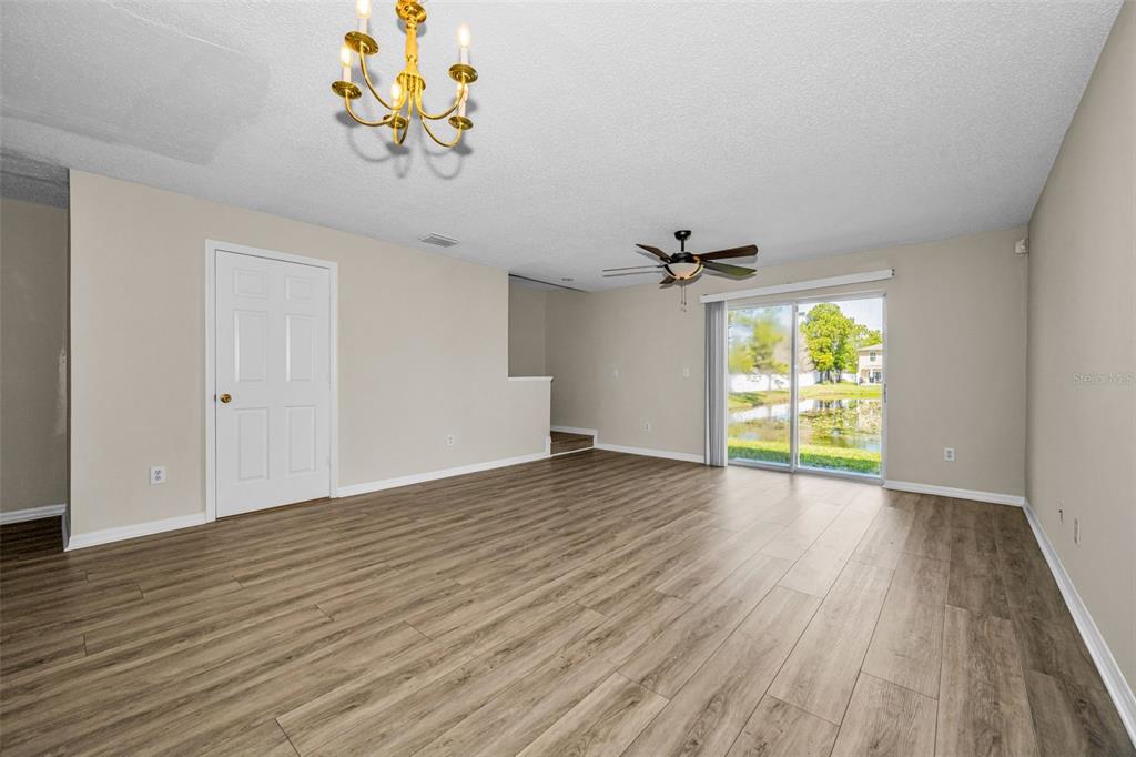 8015 Savannah Sunset Lane Tampa, FL 33615 - Photo 9 of 35 a view of an empty room with a window and wooden floor