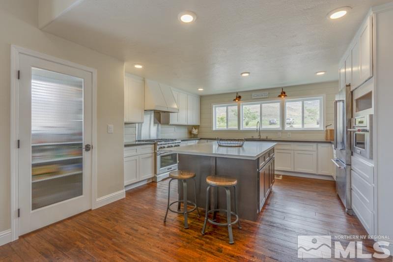 5455 Pasture View Road Reno, NV 89510 - Photo 3 of 22 a kitchen with kitchen island wooden floors and stainless steel appliances