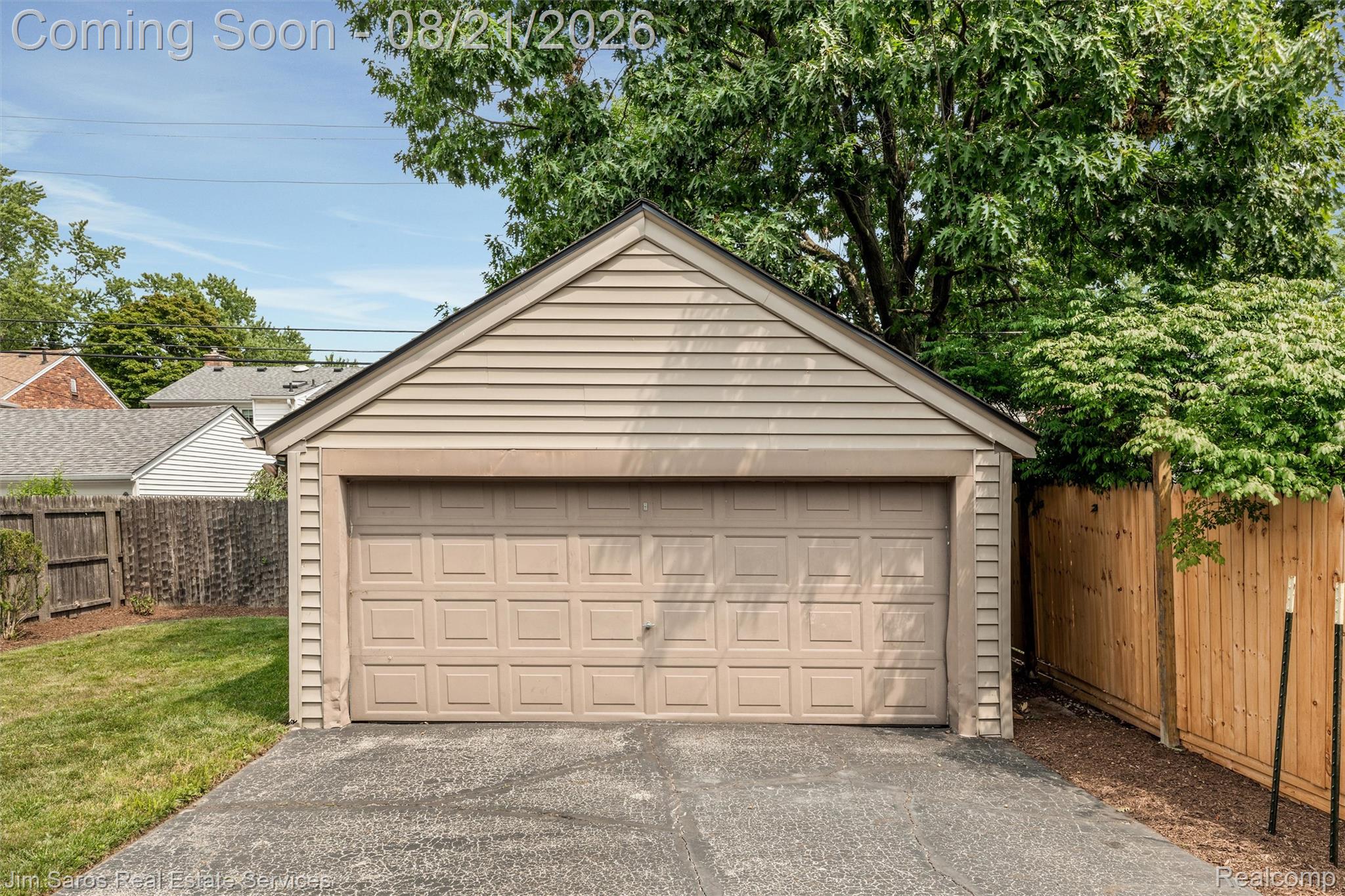 288 Moran Road Grosse Pointe, MI 48236 - Photo 23 of 24 Detached garage with horizontal siding, a paneled garage door, and a paved driveway