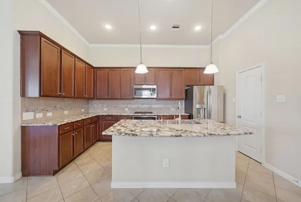 a kitchen with stainless steel appliances granite countertop a sink a stove a refrigerator and a oven