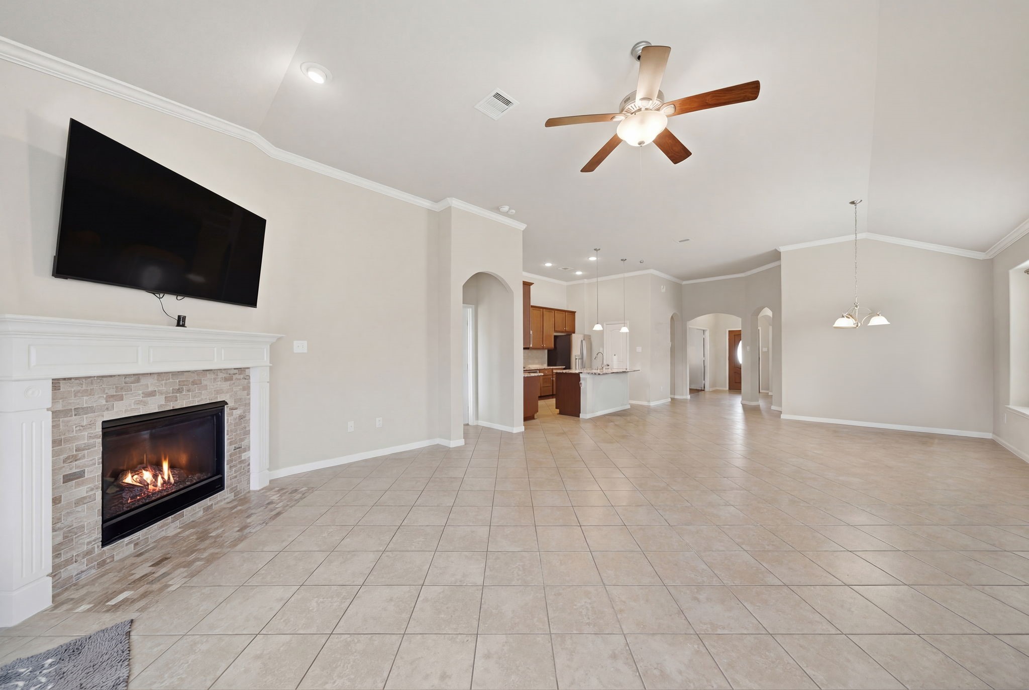 7618 Willow School Drive Spring, TX 77389 - Photo 9 of 19 a view of a livingroom with a fireplace a ceiling fan and a kitchen view