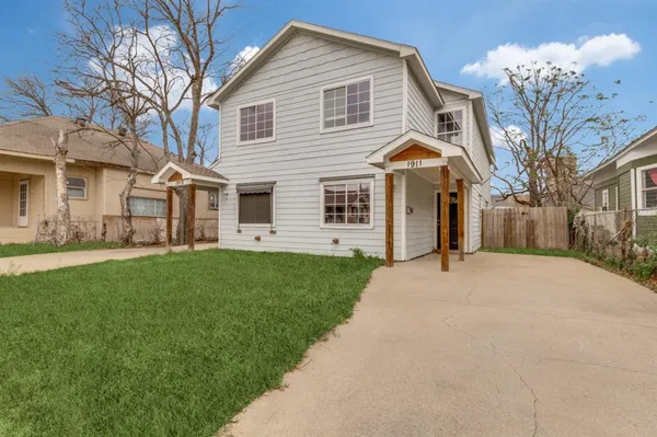 a front view of a house with a garden and trees