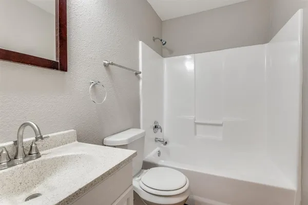 a bathroom with a toilet a sink a mirror and vanity