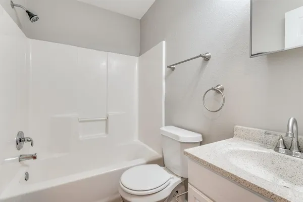 a white toilet sitting next to a bath tub