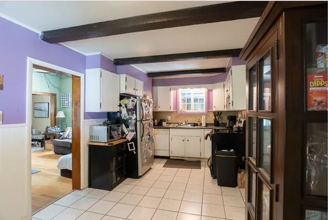 a kitchen with a sink a refrigerator and chairs
