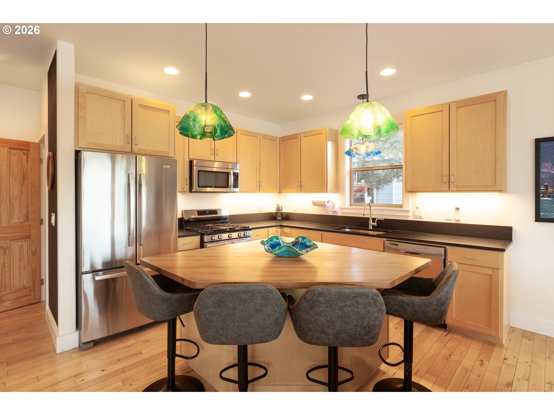 402 Bluff Road Hood River, OR 97031 - Photo 15 of 39 a kitchen with stainless steel appliances kitchen island granite countertop a table chairs and a refrigerator