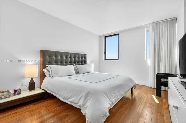 a bedroom with a large bed and a large window