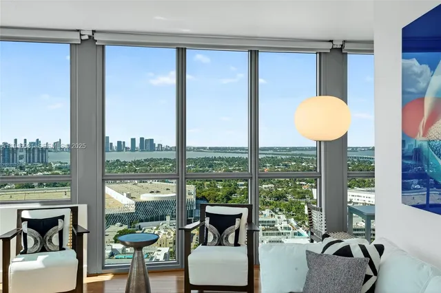 a living room with furniture and large windows