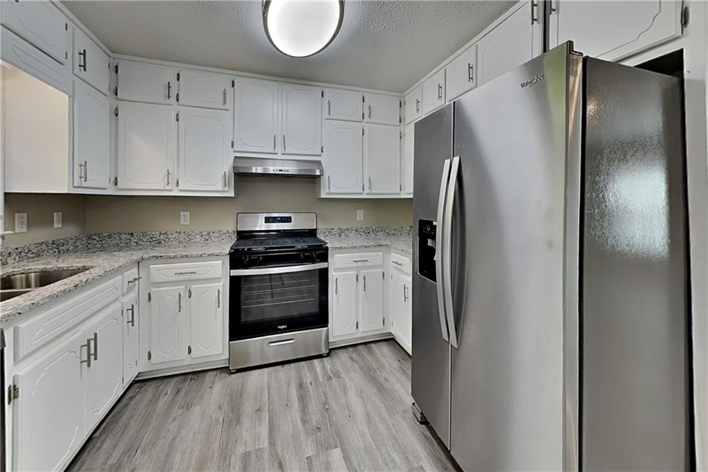 166 Kelly Court Dallas, GA 30157 - Photo 4 of 19 a kitchen with cabinets and stainless steel appliances