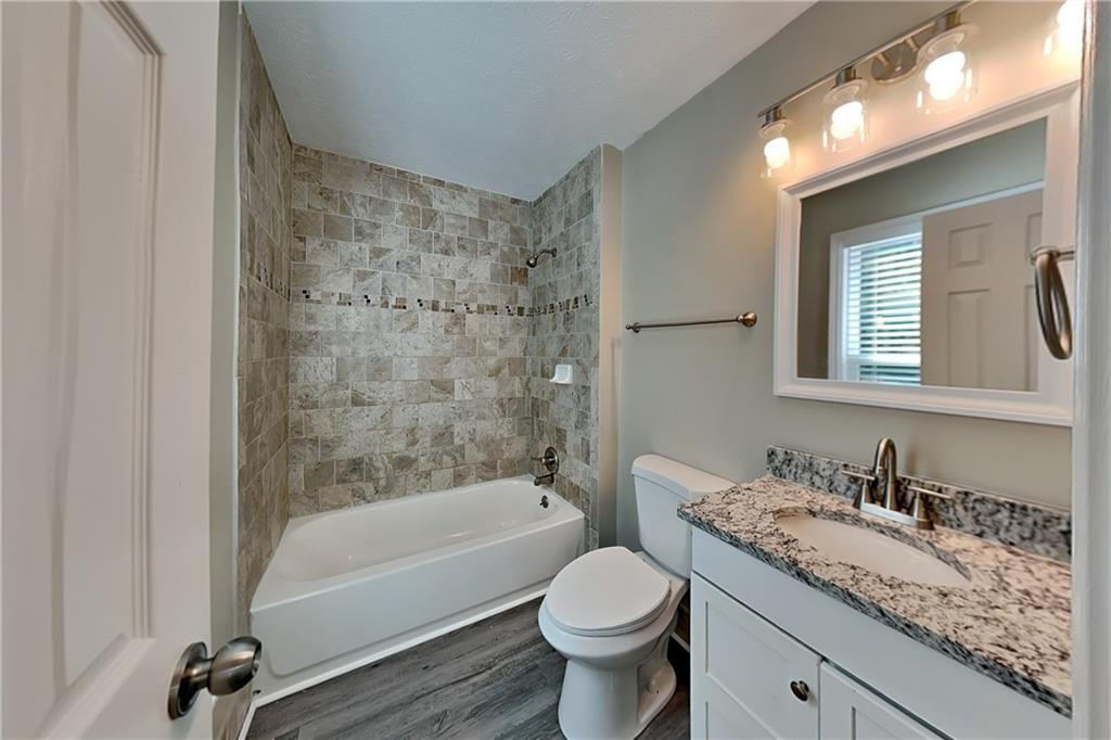 166 Kelly Court Dallas, GA 30157 - Photo 8 of 19 a bathroom with a granite countertop sink a toilet and bathtub