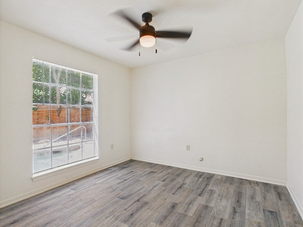 6108 Shadow Valley Drive, Unit A Austin, TX 78731 - Photo 23 of 31 an empty room with wooden floor and windows
