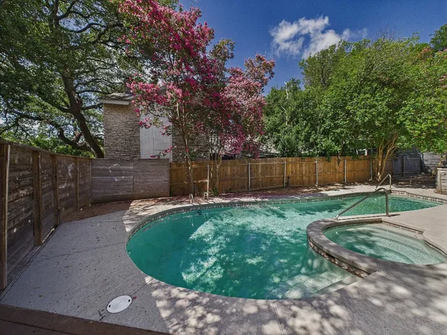 a view of a backyard with wooden fence