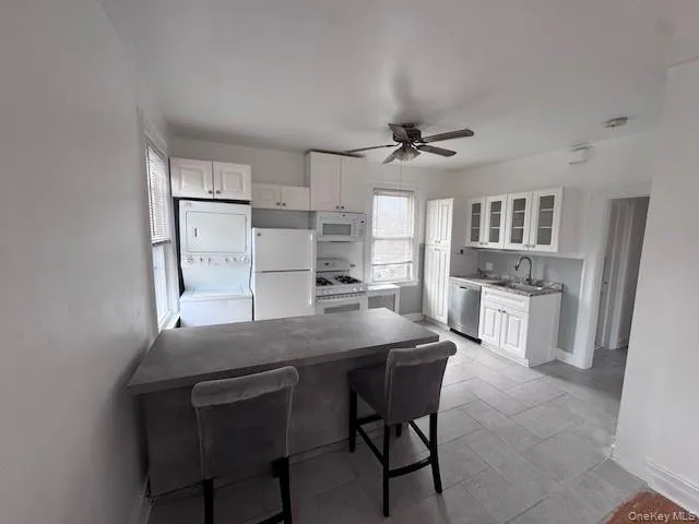 a kitchen with granite countertop a table chairs refrigerator and cabinets