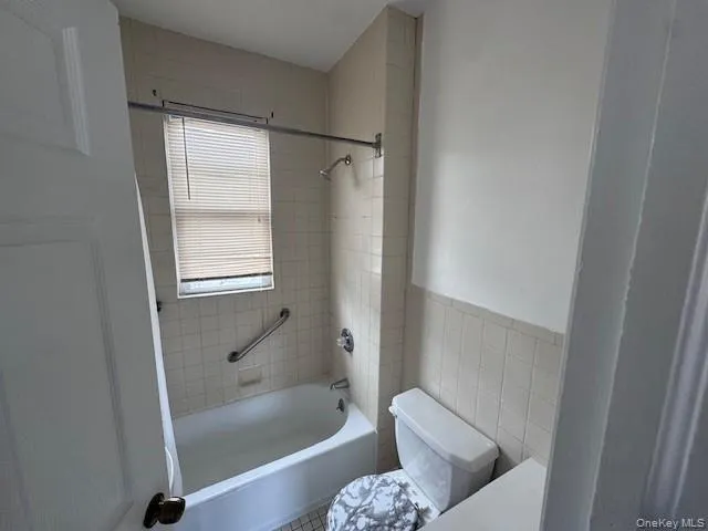 a bathroom with a tub shower and toilet