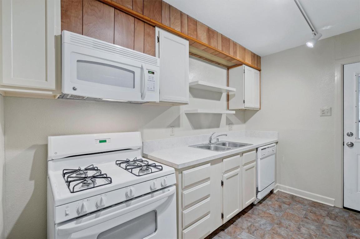 1511 Alguno Road Austin, TX 78757 - Photo 5 of 25 a kitchen with white cabinets and white appliances