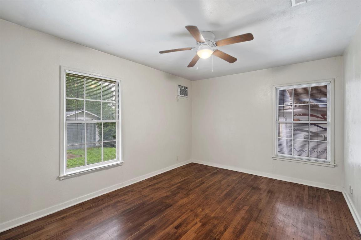 1511 Alguno Road Austin, TX 78757 - Photo 7 of 25 a view of an empty room with wooden floor and a window