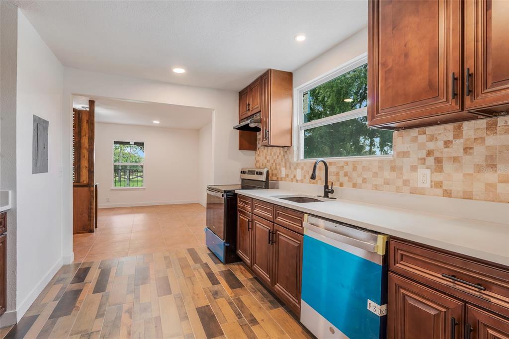 13832 South Bay Lake Road Groveland, FL 34736 - Photo 6 of 55 a kitchen with kitchen island granite countertop a sink stainless steel appliances and cabinets