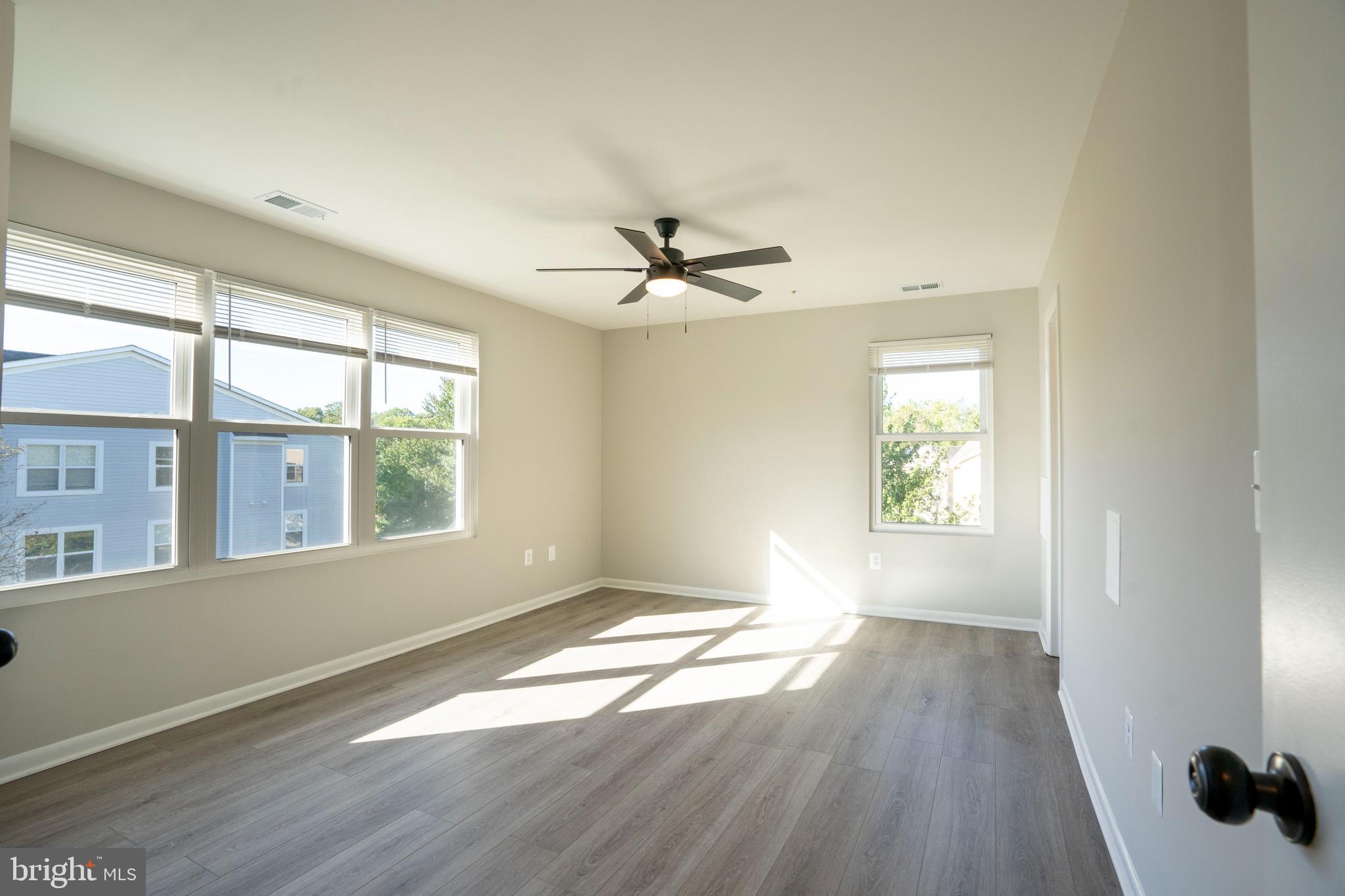 30 I Greystone Court, Unit I Annapolis, MD 21403 - Photo 2 of 15 an empty room with wooden floor and windows