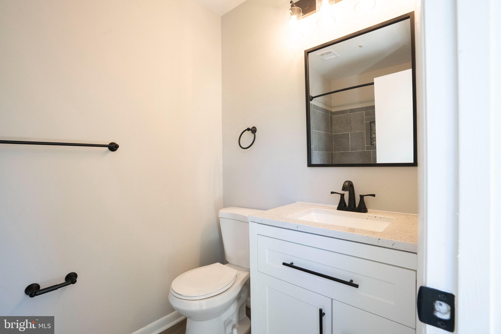 30 I Greystone Court, Unit I Annapolis, MD 21403 - Photo 5 of 15 a bathroom with a toilet sink and mirror