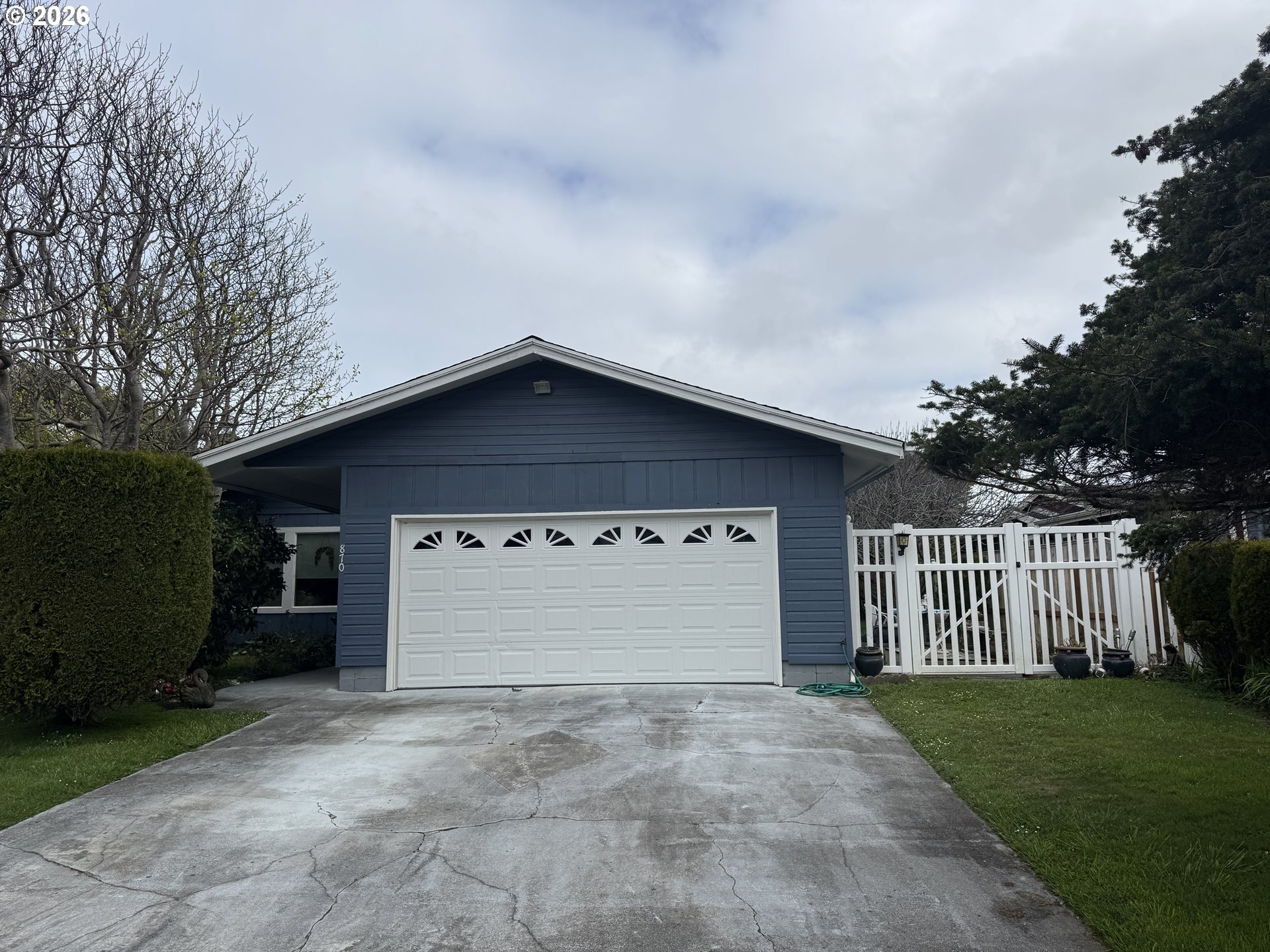 870 12th Street Southwest Bandon, OR 97411 - Photo 1 of 25 a front view of a house with a yard and garage
