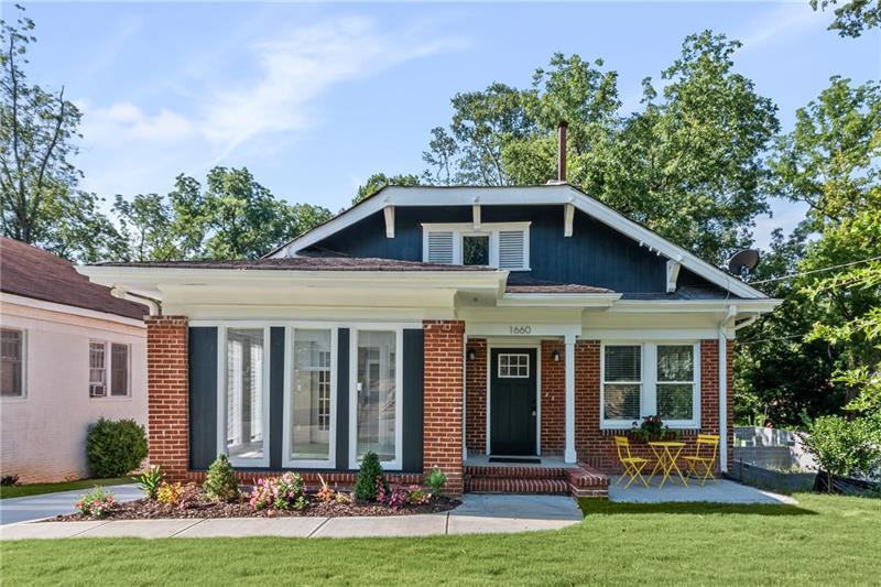 a front view of a house with yard and green space