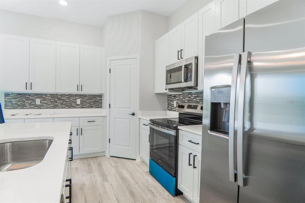 4540 Southwest 170th Street Road Ocala, FL 34473 - Photo 10 of 34 a kitchen with cabinets stainless steel appliances and wooden floor
