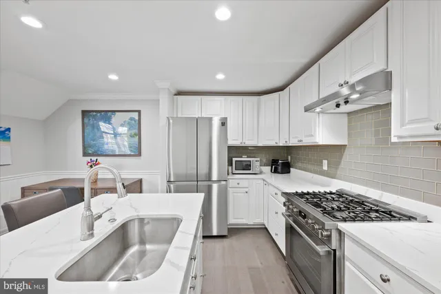 a kitchen with stainless steel appliances granite countertop a sink stove and refrigerator