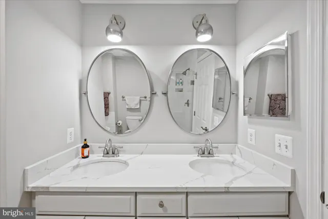 a bathroom with double vanity sinks and a mirror
