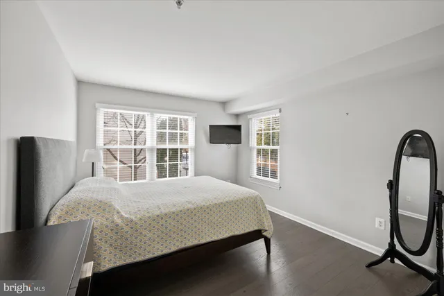 a bedroom with a bed a mirror and a window