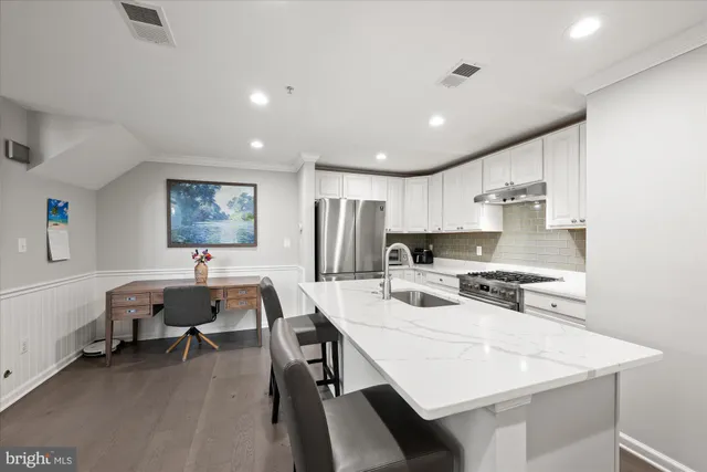 a large kitchen with kitchen island a dining table and chairs
