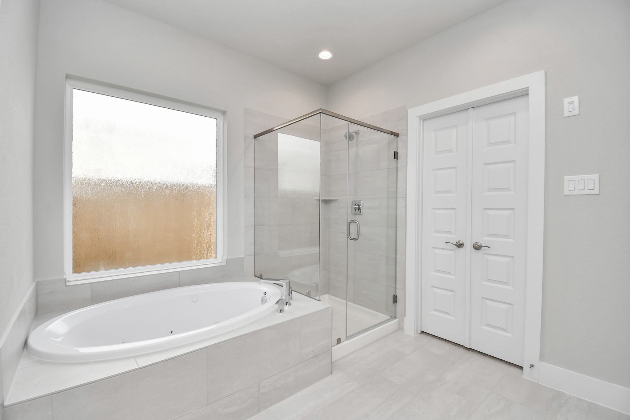 3038 Native Spg Drive Spring, TX 77373 - Photo 24 of 40 Indulge in a spa-like retreat within the confines of this primary bathroom. Delight in a spacious walk-in shower enveloped in stylish tile surround and unwind in a separate garden tub adorned with custom detailing. Sample photo of completed home with similar floor plan. Actual colors and selections may vary.