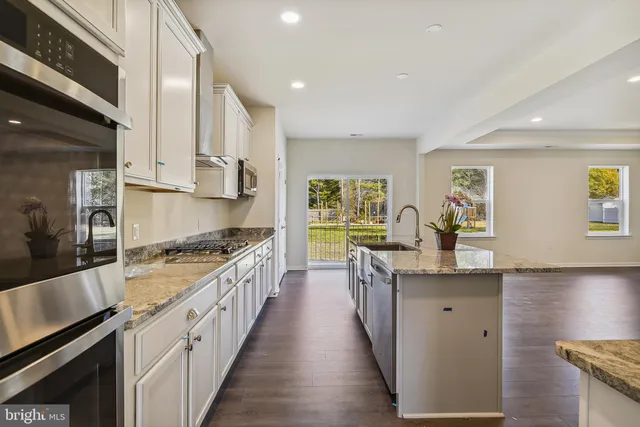a kitchen with stainless steel appliances granite countertop a stove a sink and a refrigerator