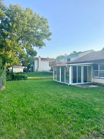 a view of yard with green space and trees in the background