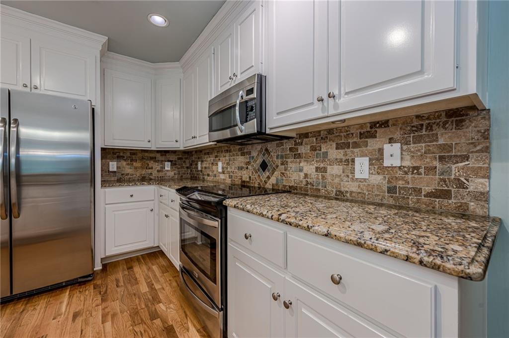 461 Braidwood Walk Northwest Acworth, GA 30101 - Photo 28 of 67 a kitchen with stainless steel appliances granite countertop a sink stove and refrigerator