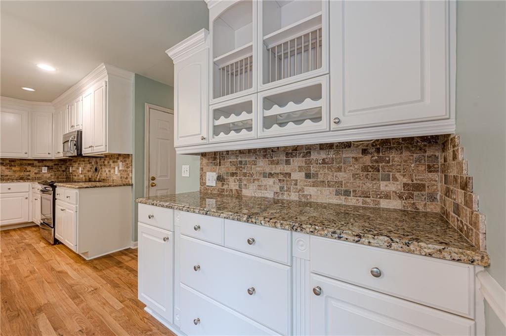 461 Braidwood Walk Northwest Acworth, GA 30101 - Photo 30 of 67 a kitchen with granite countertop white cabinets and white appliances