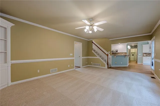 a view of a livingroom with wooden floor and stairs