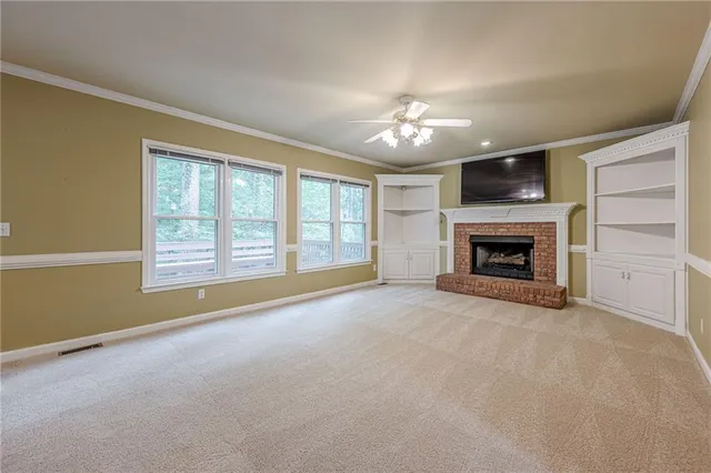 a view of an empty room with a fireplace and a window