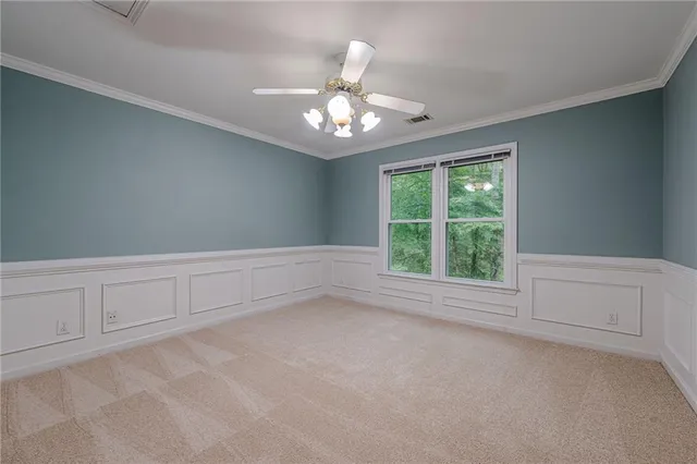 an empty room with closet and a ceiling fan