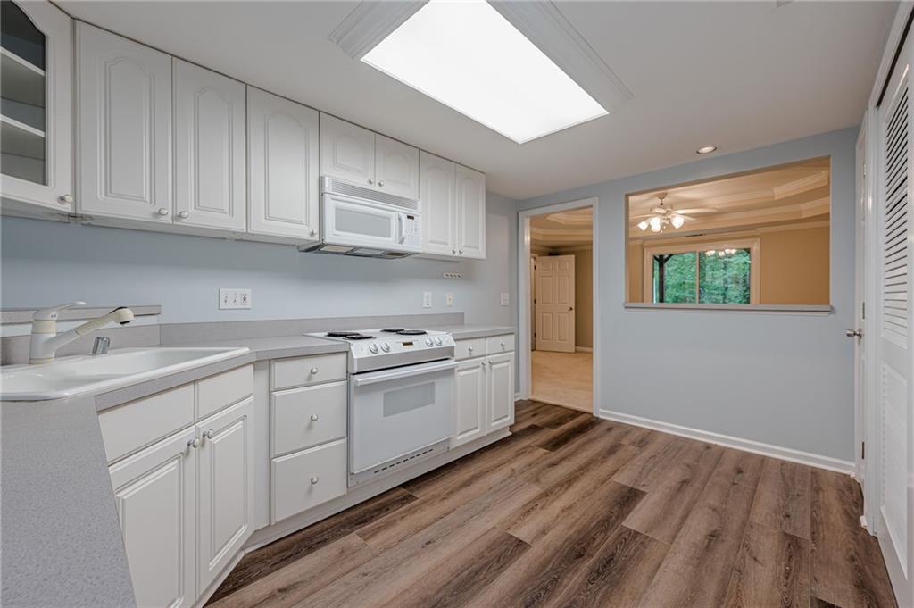 461 Braidwood Walk Northwest Acworth, GA 30101 - Photo 59 of 67 a kitchen with granite countertop white cabinets and white appliances