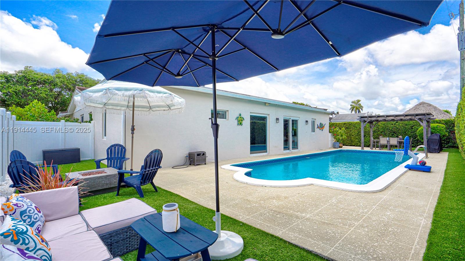 9573 Southwest 57th Street Miami, FL 33173 - Photo 3 of 34 a patio with a table and chairs under an umbrella