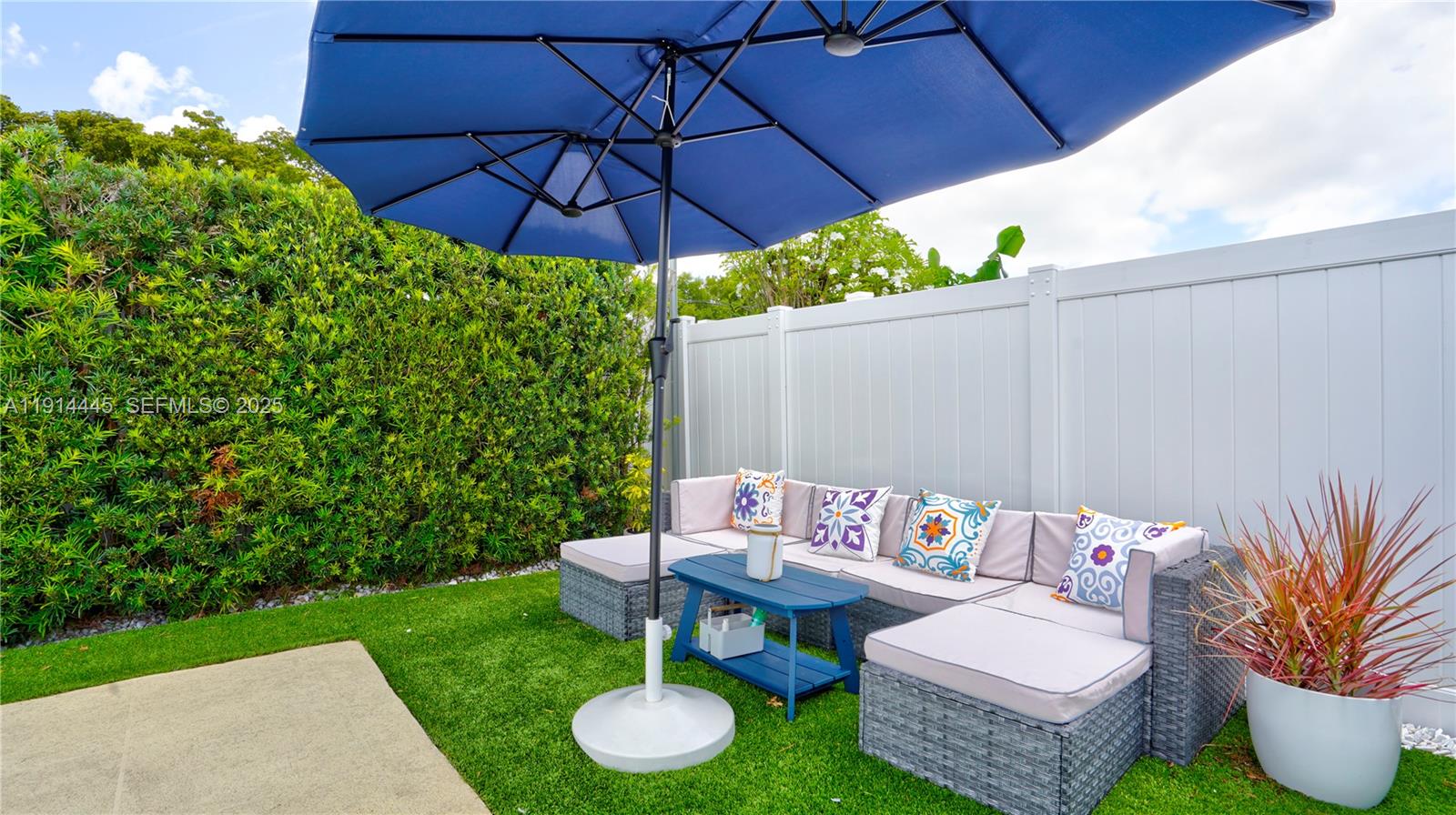 9573 Southwest 57th Street Miami, FL 33173 - Photo 31 of 34 a patio with a table and chairs under an umbrella