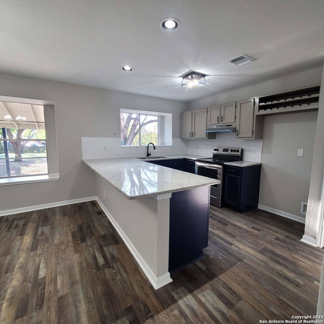 14623 Highland Ridge San Antonio, TX 78233 - Photo 13 of 37 a kitchen with stainless steel appliances granite countertop a sink stove and refrigerator