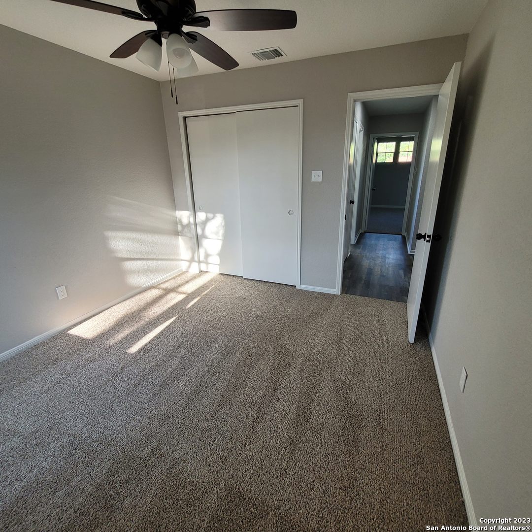 14623 Highland Ridge San Antonio, TX 78233 - Photo 27 of 37 an empty room with chandelier fan and windows