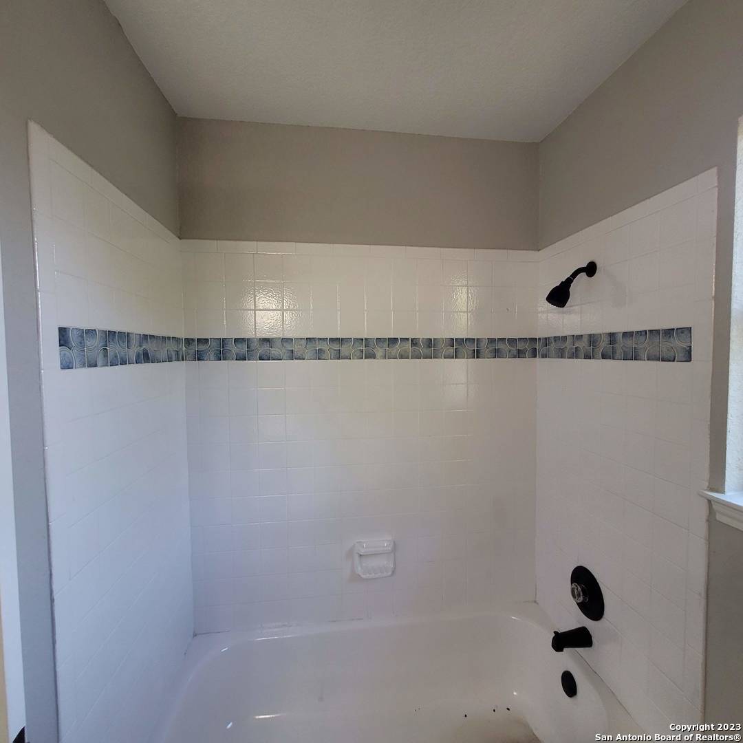 14623 Highland Ridge San Antonio, TX 78233 - Photo 29 of 37 a bathroom with a shower and a bath tub