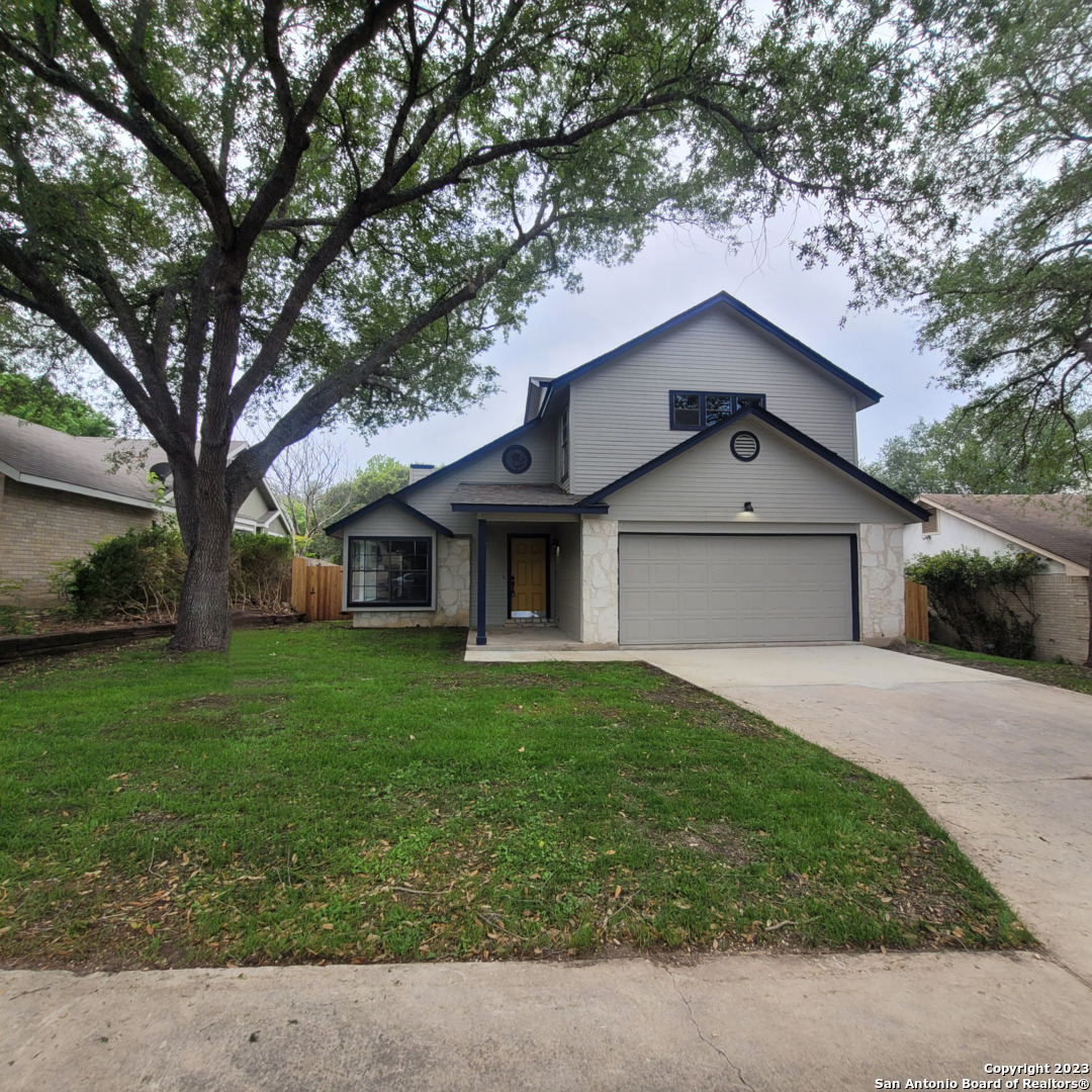 14623 Highland Ridge San Antonio, TX 78233 - Photo 4 of 37 a front view of a house with a garden and trees