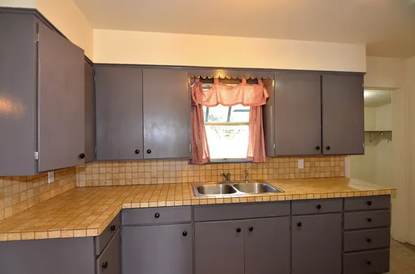 a kitchen with a sink cabinets and window