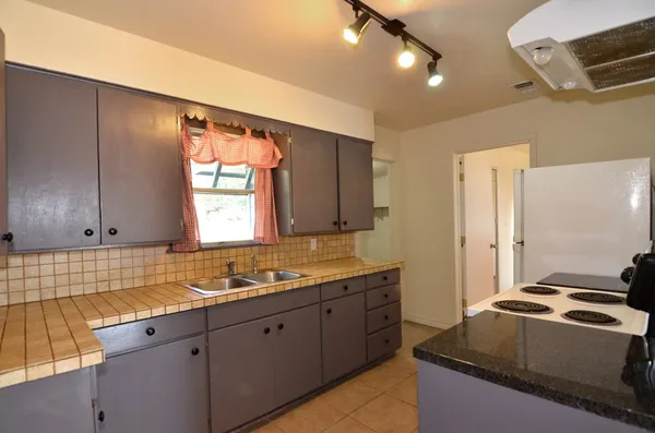 a kitchen with a sink stove and cabinets
